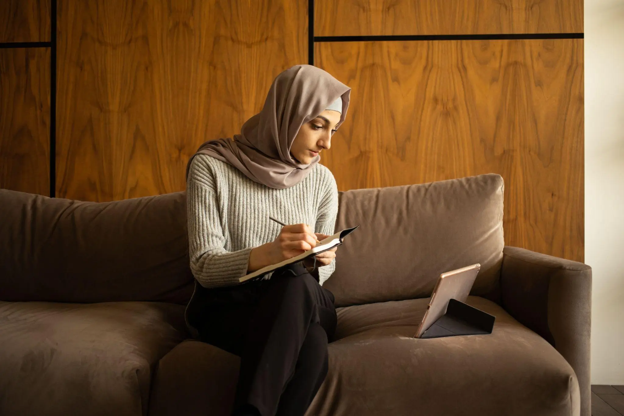 Student in hijab watching lecture videos 